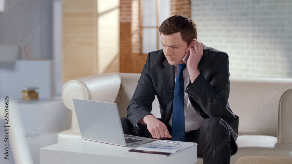 Businessman talking on cell phone in modern office, solving company issues Businessman talking on cell phone in modern office, solving company issues