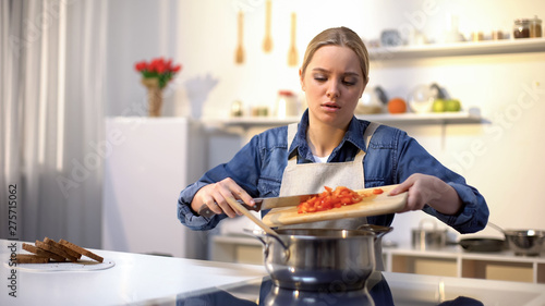 Young beautiful woman unhappy with cooking in kitchen  bored and tired of chores