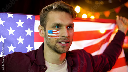Concentrated fan of american basketball watching game in pub with national flag