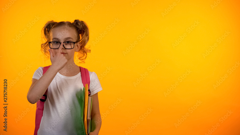Adorable girl in glasses ready for school, holding notebooks and bag, education Adorable girl in glasses ready for school, holding notebooks and bag, education