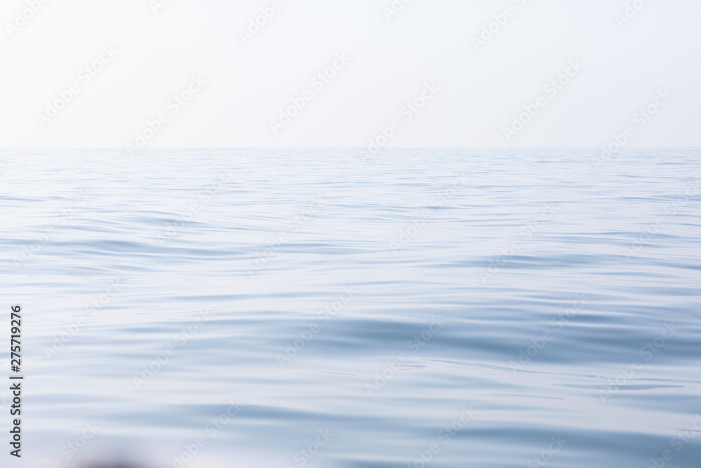 Naklejka premium Tranquil and serene ocean surface. Calm and relaxed mirror-like blue sea background.