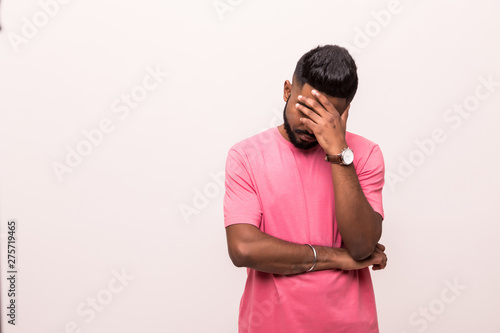 Photography Young indian man in gloomy mood with head on hands and ruffled hair