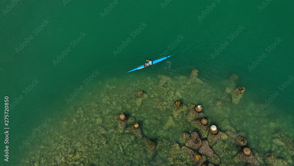 Aerial drone photo of young men competing with sport canoe in tropical lake with calm waters Aerial drone photo of young men competing with sport canoe in tropical lake with calm waters