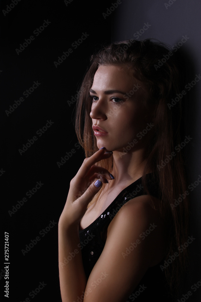 Beautiful portrait of a girl in a shiny vest on a black background photo for text Beautiful portrait of a girl in a shiny vest on a black background photo for text