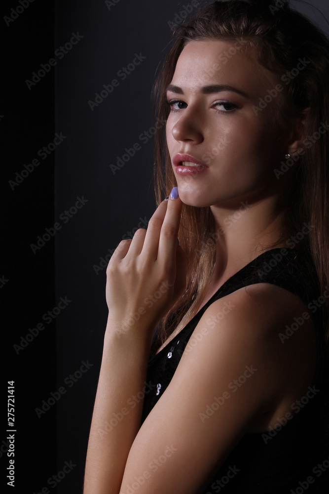 Beautiful portrait of a girl in a shiny vest on a black background photo for text Beautiful portrait of a girl in a shiny vest on a black background photo for text
