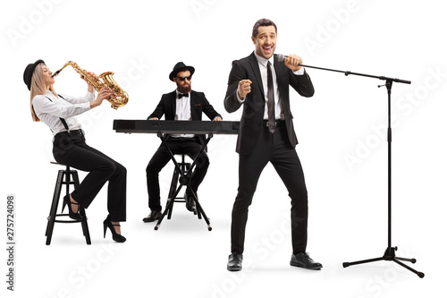 Canvas Print Woman playing sax, man playing a keyboard and a male singer singing on a microph
