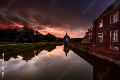 Schloss am Wasser beim Sonnenuntergang, Brücke, See, roter Himmel