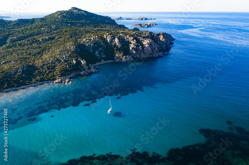 View from above, stunning aerial view of a sailing boat floating on a beautiful turquoise clear sea. Maddalena Archipelago National Park, Sardinia, Italy.