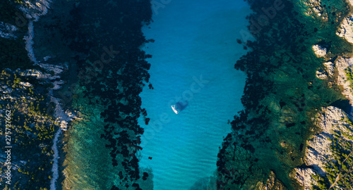 View from above, stunning aerial view of a sailing boat floating on a beautiful turquoise clear sea. Maddalena Archipelago National Park, Sardinia, Italy.