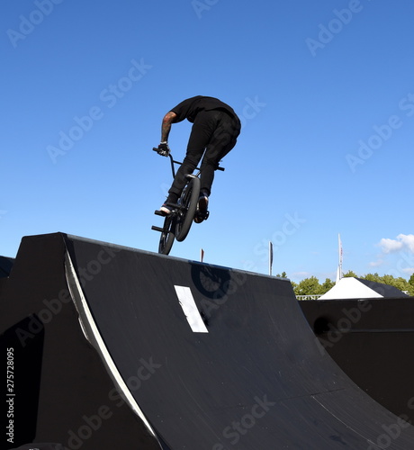 Über die Rampe einer Halfpipe springender BMX-Freestyler photo