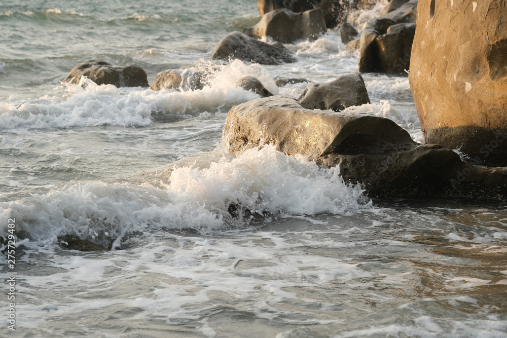 Naklejka premium Seawaves hitting rocks on beach.