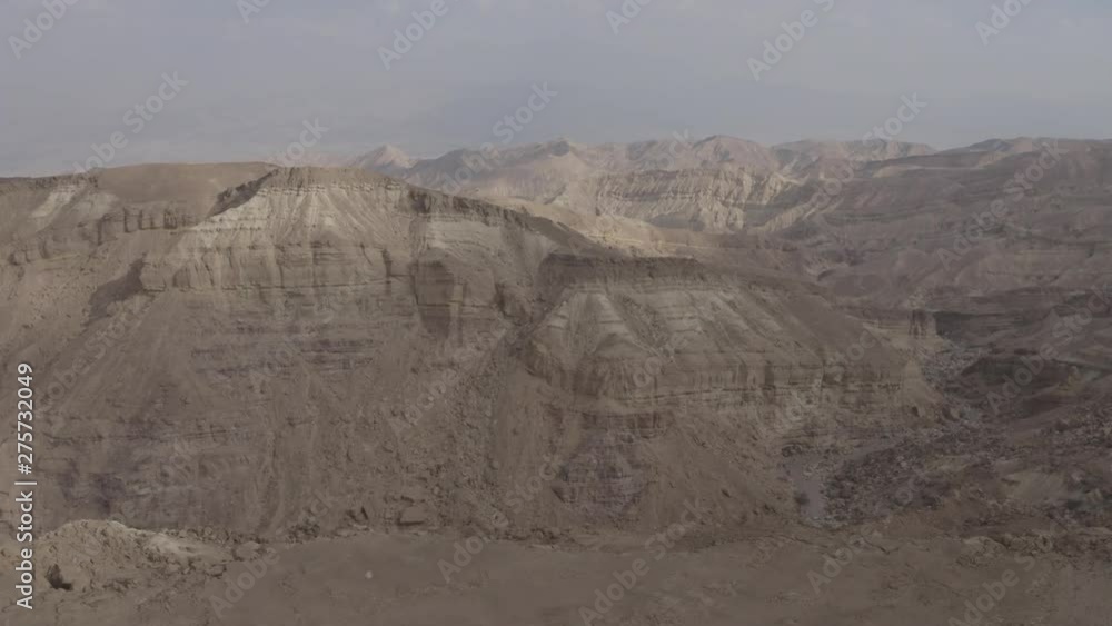 Drone flies over the barren moon landscape of the Israeli desert Negev. The rugged cliffs and the radiant desert sun make this landscape look like something from another world Drone flies over the barren moon landscape of the Israeli desert Negev. The rugged cliffs and the radiant desert sun make this landscape look like something from another world