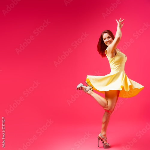 Beautiful woman with healthy body wearing in a dress dancing and spinning around on pink background.The concept of summer fashion clothes and relaxation. pink and joyful mood.