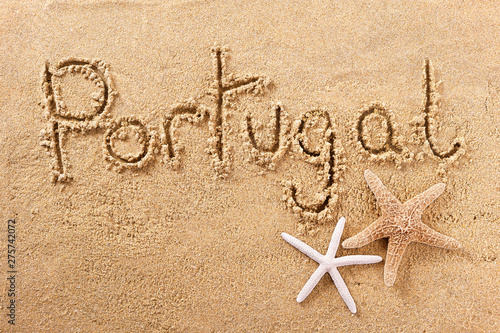 Portugal word written in sand on a sunny summer beach with starfish holiday vacation travel destination sign writing message photo