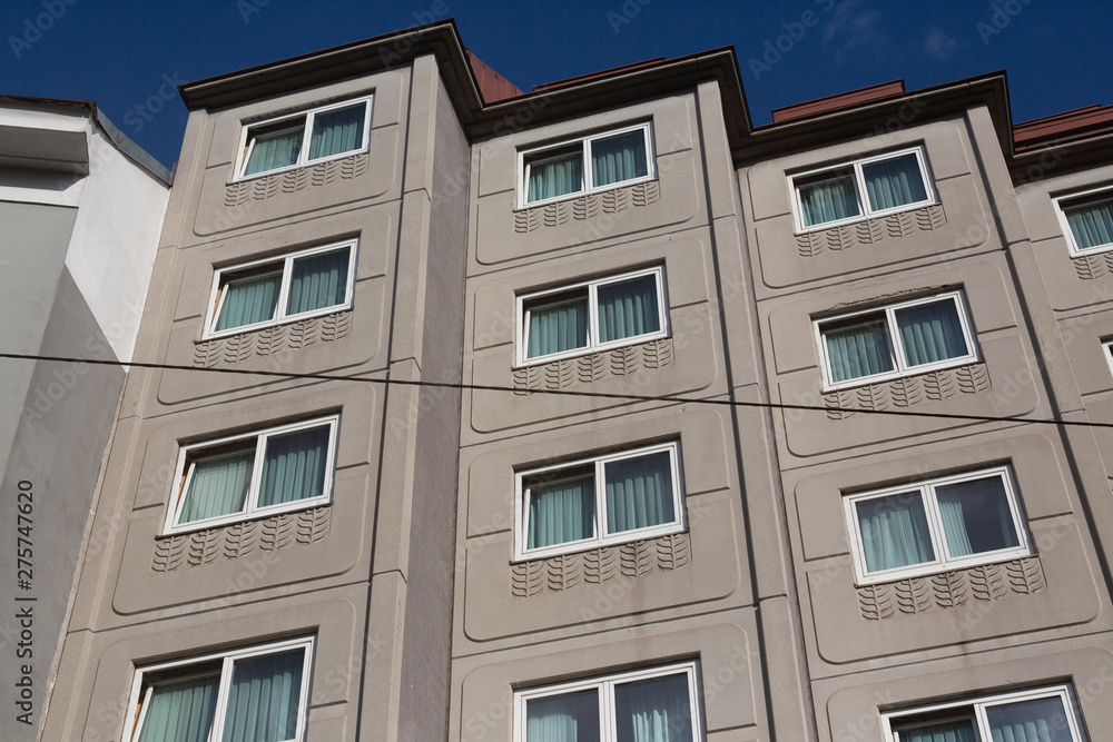 facade of modernist european apartment building against blue sky