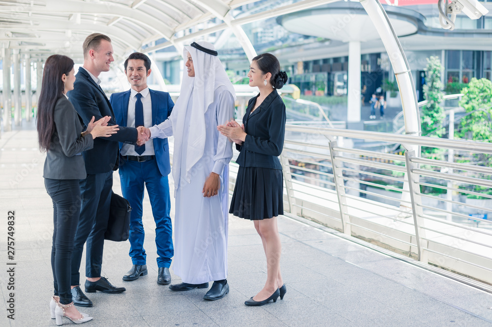 Multi-ethnic businessman standing and shaking hand in the city for successful in Business Cooperation. multi culture of business people, African, Caucasian and Asian.