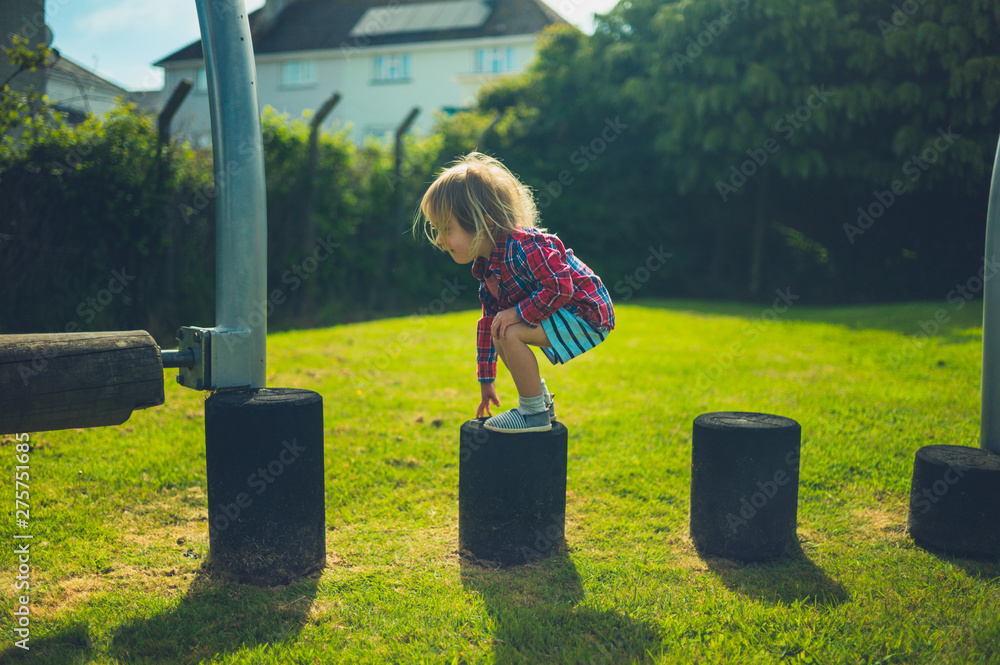Little toddler balancing at the playground - obrazy, fototapety, plakaty 
