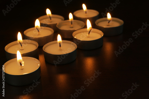 Burning candles on table in darkness. Romance  celebration and memorial symbol.