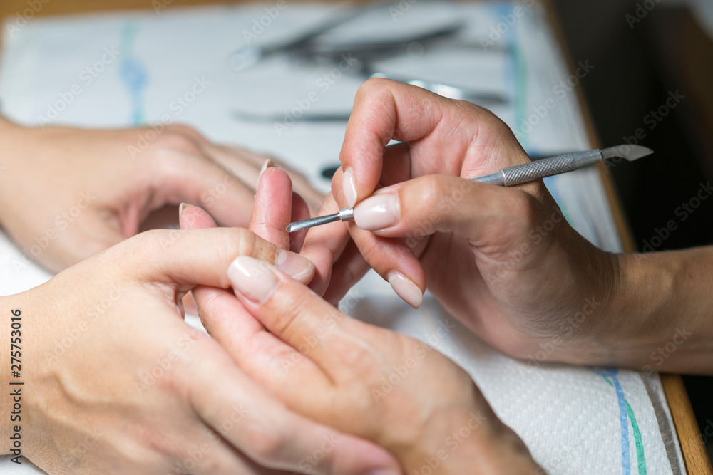 Close up woman hand while process of manicure in nail shop. Beautiful concept. female nail manicure processing Close up woman hand while process of manicure in nail shop. Beautiful concept. female nail manicure processing