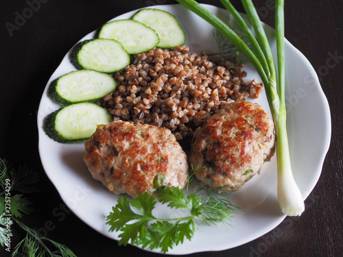 Tableau sur toile Appetizing homemade chopped steak with buckwheat to eat with herbs and vegetables