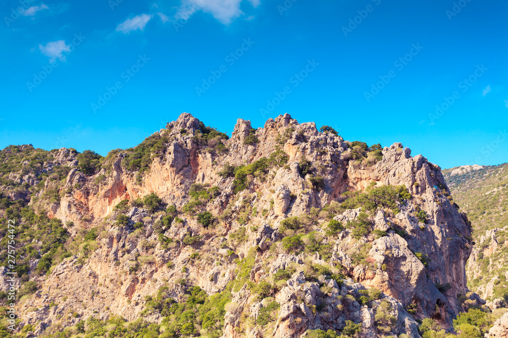 Mountain cliffs against sky with clouds