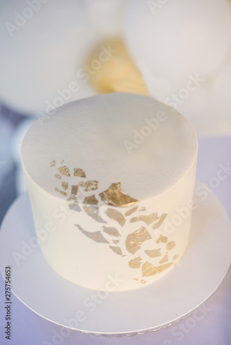 Candy bar and white cake decorated golden confectionery sprinkles on white background