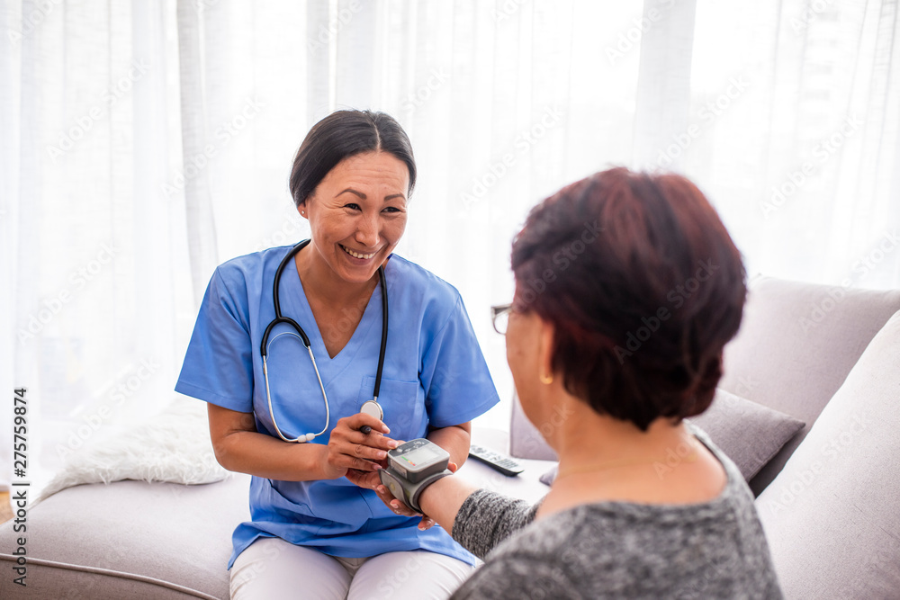 Portrait of young Asian nurse with elderly woman. Helpful volunteer taking care of senior lady at healthcare home. Picture of a senior lady with her friendly caregiver. Portrait of young Asian nurse with elderly woman. Helpful volunteer taking care of senior lady at healthcare home. Picture of a senior lady with her friendly caregiver.