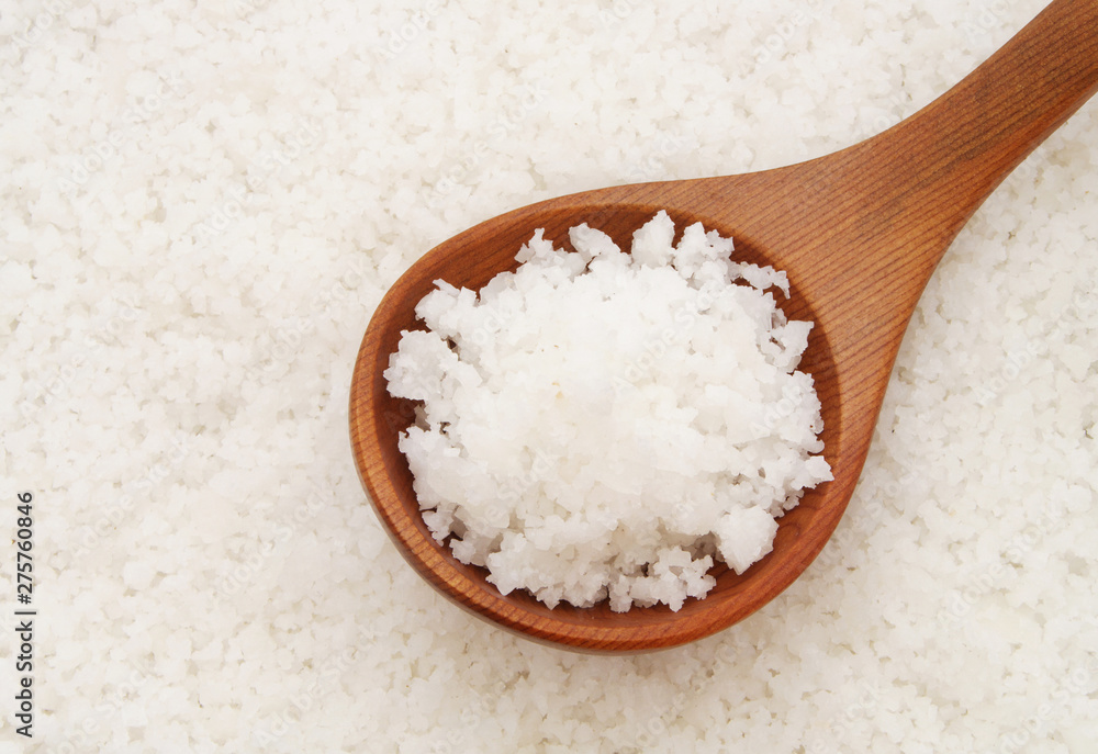 Wooden spoon with salt on sea salt background Wooden spoon with salt on sea salt background