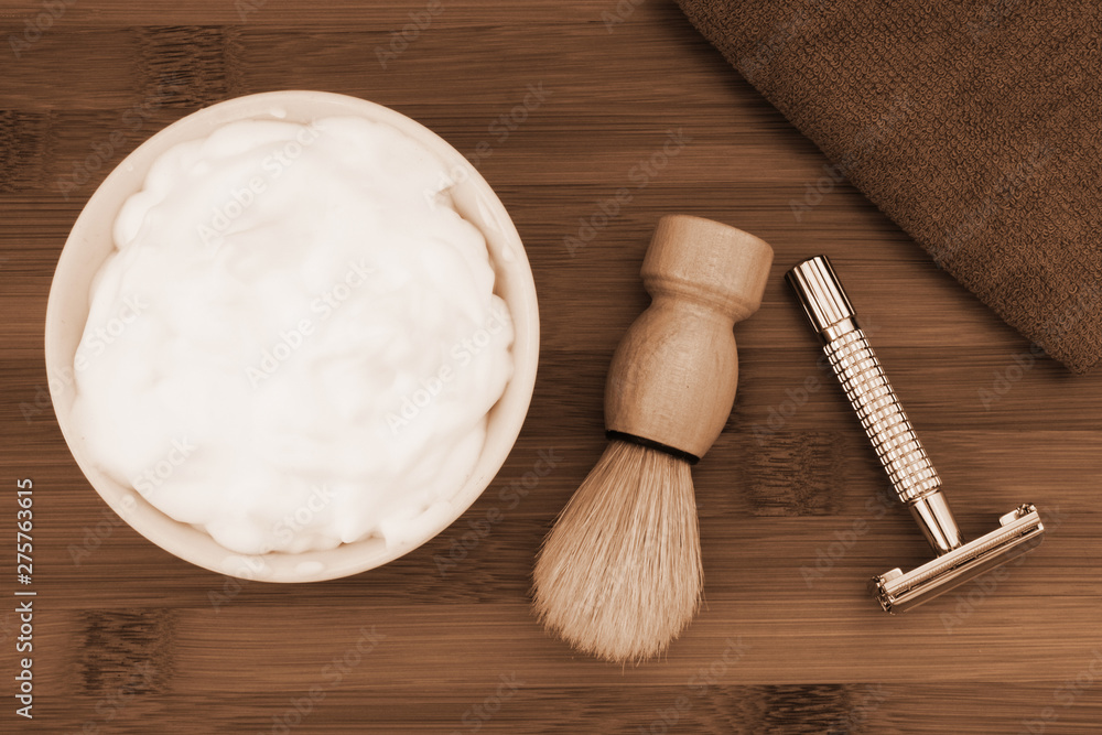 Shaving accessories on wooden background. Razor, brush, towel and foam in bowl. Shaving accessories on wooden background. Razor, brush, towel and foam in bowl.