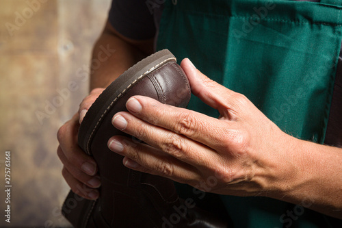 Foto shoemaker checks a repaired shoe sole