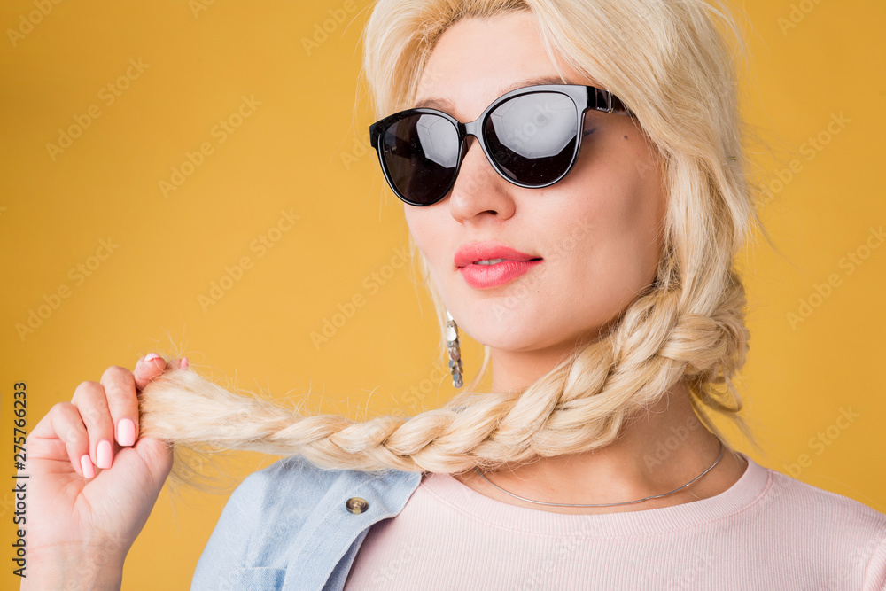 Close up photo of beautiful woman in sunglasses isolated on yellow background Close up photo of beautiful woman in sunglasses isolated on yellow background