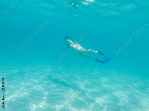 active woman swimming in beautiful blue ocean