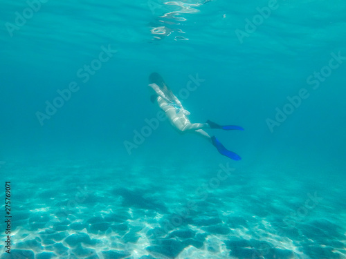 Woman diving in clear turquoise water © Glyph_stock