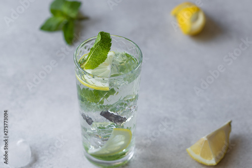 mint lemonade on grey background with lemon zest and mint leaves
