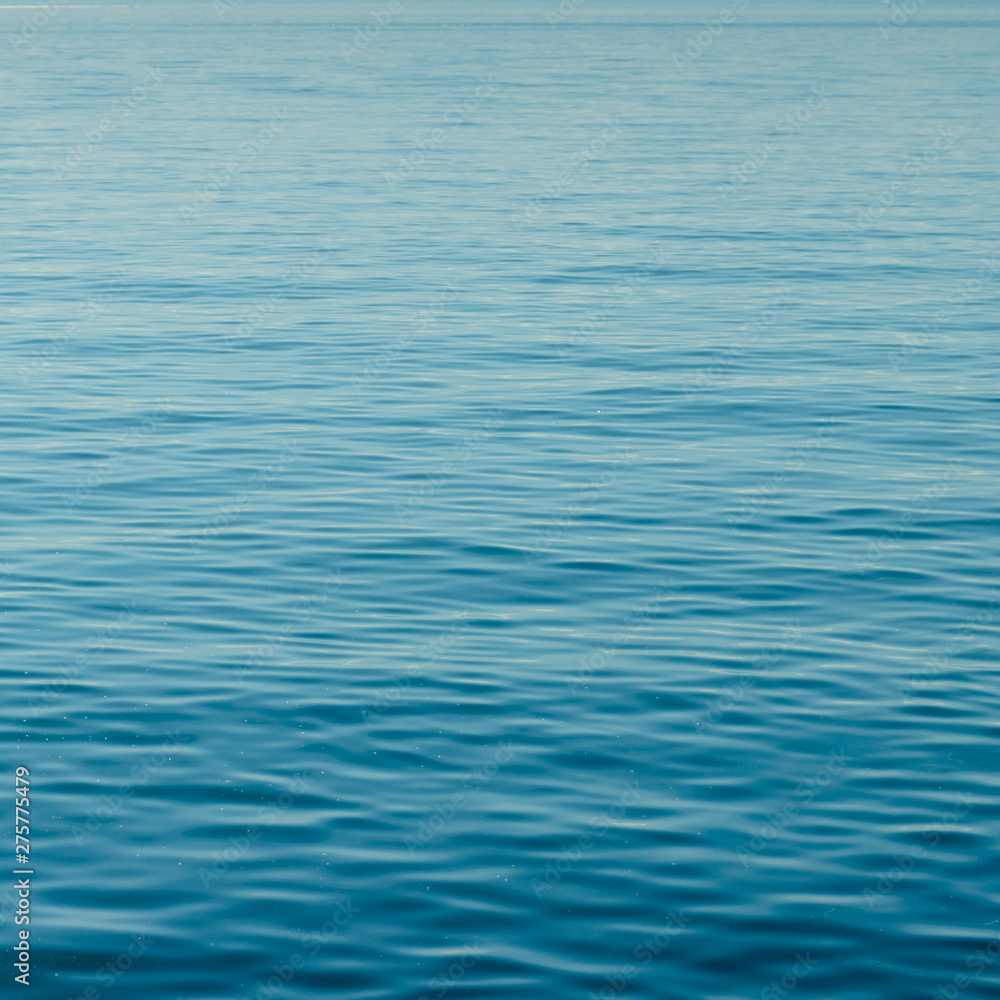 background of calm blue water with small waves and endless ripples background of calm blue water with small waves and endless ripples