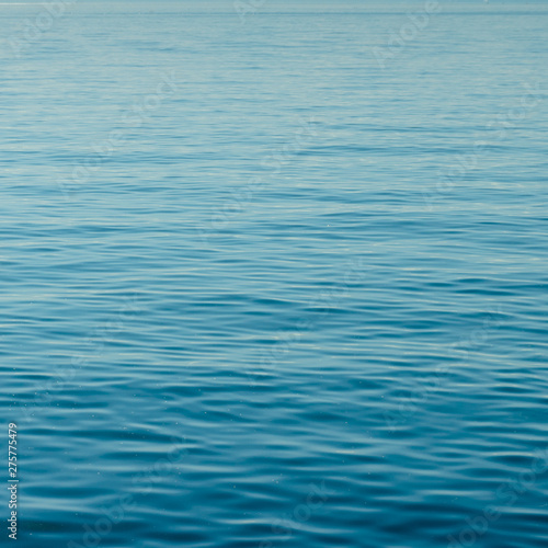 background of calm blue water with small waves and endless ripples