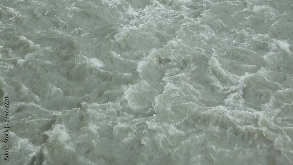 Spring muddy mountain river rages, flows from top to bottom Spring muddy mountain river rages, flows from top to bottom