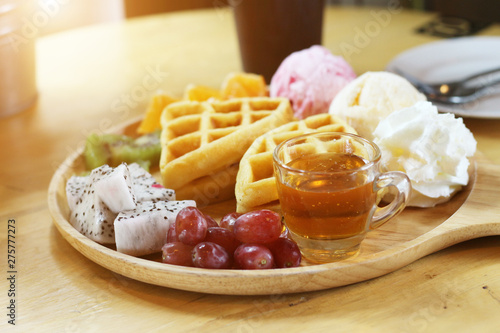 waffles with fruit and ice cream on wood plate