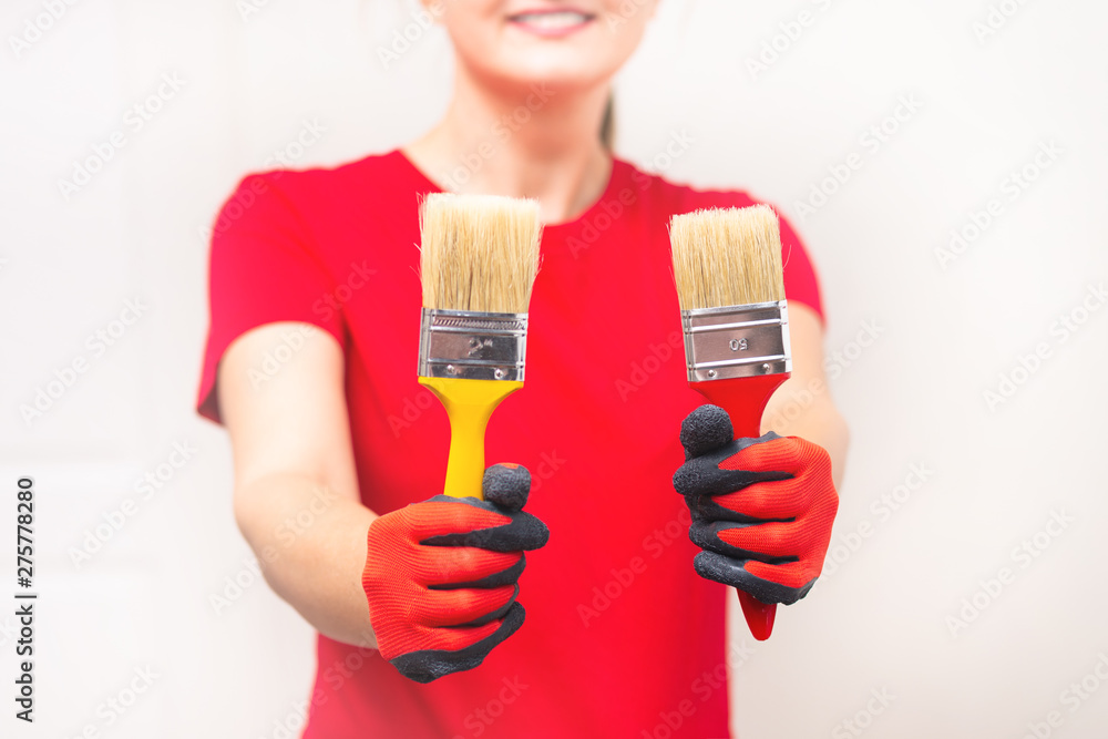 Woman holding paint brush starting repairing the home Woman holding paint brush starting repairing the home