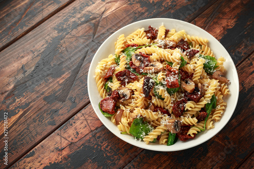 Fusilli Pasta with sun dried tomatoes, mushrooms, parmesan cheese and spinach. healthy food. photo