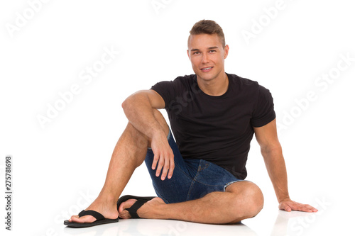 Relaxed Man Is Sitting On A Floor And Smiling