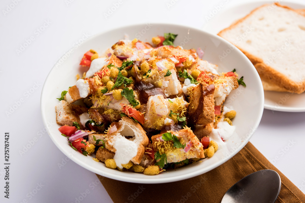 Bread chaat/chat is a yummy starter/appetizer from India, served in a bowl garnished with tomato, sev and coriander and masala. selective focus Bread chaat/chat is a yummy starter/appetizer from India, served in a bowl garnished with tomato, sev and coriander and masala. selective focus