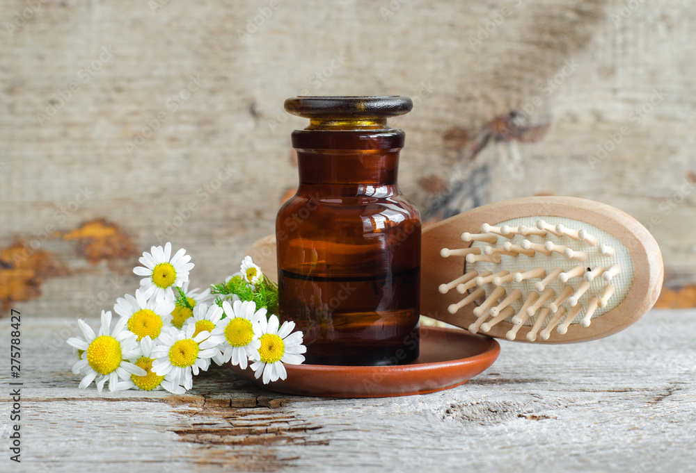 Pharmacy bottle with roman chamomile essential oil (extract, tincture, infusion) and wooden hair brush. Old wooden background. Aromatherapy, natural hair care, spa, herbal medicine concept. Copy space Stock Photo | Adobe Stock Pharmacy bottle with roman chamomile essential oil (extract, tincture, infusion) and wooden hair brush. Old wooden background. Aromatherapy, natural hair care, spa, herbal medicine concept. Copy space Stock Photo | Adobe Stock