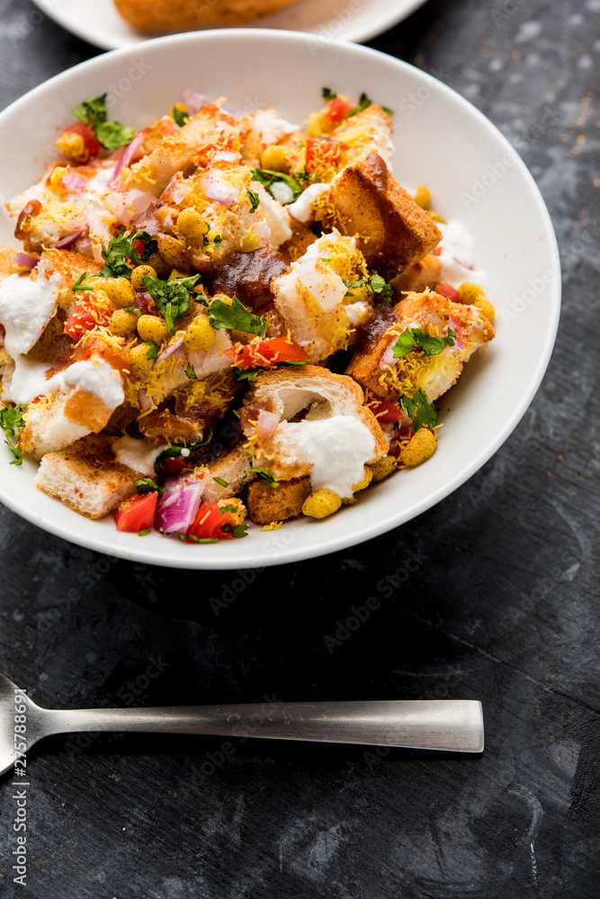 Bread chaat/chat is a yummy starter/appetizer from India, served in a bowl garnished with tomato, sev and coriander and masala. selective focus Bread chaat/chat is a yummy starter/appetizer from India, served in a bowl garnished with tomato, sev and coriander and masala. selective focus