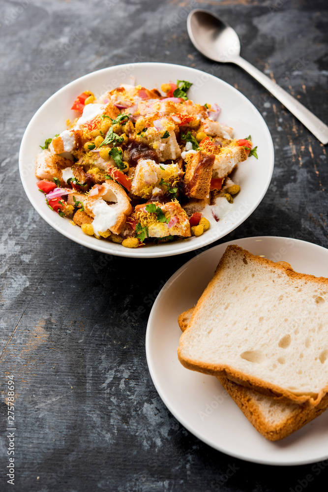 Bread chaat/chat is a yummy starter/appetizer from India, served in a bowl garnished with tomato, sev and coriander and masala. selective focus Bread chaat/chat is a yummy starter/appetizer from India, served in a bowl garnished with tomato, sev and coriander and masala. selective focus