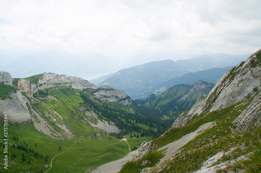 Pilatus mountain range in the Swiss Alps, Lucerne. Panoramic view from the height between the mountains to the green valley.