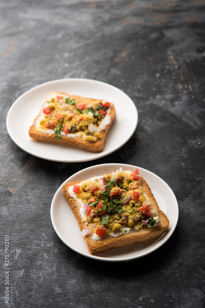 Bread ppadi chaat/chat is a yummy starter/appetizer from India, served in a plate garnished with tomato, sev and coriander and masala. selective focus Bread ppadi chaat/chat is a yummy starter/appetizer from India, served in a plate garnished with tomato, sev and coriander and masala. selective focus