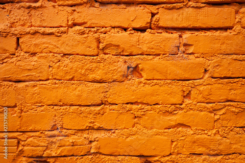 Detail of a brick wall painted in vivid orange