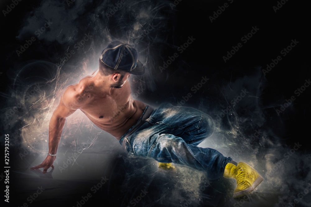 Hip hop dancer showing some movements on dark background Hip hop dancer showing some movements on dark background