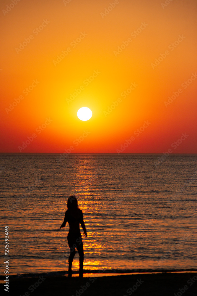 woman watching the sunset on the beach. the concept of a healthy lifestyle